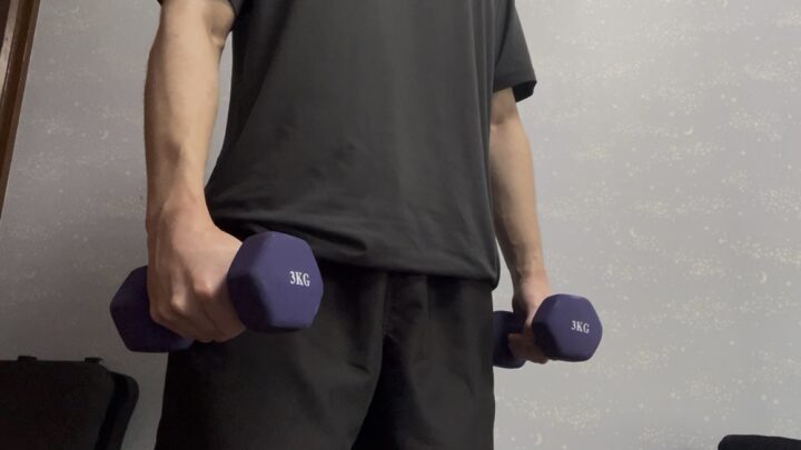 ダンベルを体の横に持つ人
